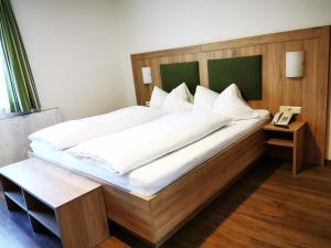 a bedroom with a large bed with a wooden headboard at Pension Bergwelt in Neustift im Stubaital