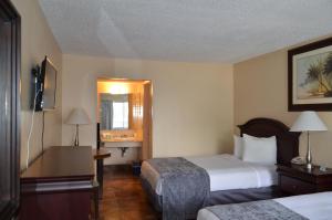 um quarto de hotel com duas camas e uma televisão em Altamonte Springs Hotel and Suites em Orlando