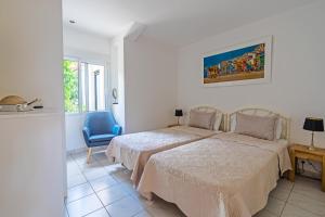 a bedroom with a bed and a blue chair at Maryvilla Inspiración y Vacaciones - Villa Mascarat in Calpe +73 photos