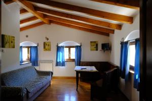 sala de estar con cortinas azules y sofá en Casa Vacanze Campo d'Arco, en Nocera Umbra