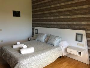 a bedroom with a bed and a wooden wall at Hotel Rural Porta Coeli - Dehesa Santa Lucía in San Martín del Castañar