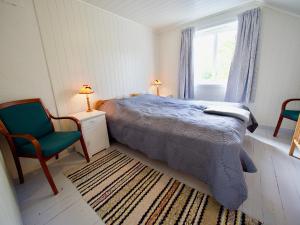 - une chambre avec un lit, une chaise et une fenêtre dans l'établissement Vestfjorden Panorama Lofoten, à Valberg