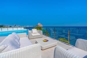 a patio with wicker furniture and a view of the ocean at Maryvilla Inspiracion y Vacaciones - Grand Villa Penon in Calpe