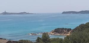a view of the ocean with a boat in the water at VILLA CLAUDIO e LUNETTA in Villasimius