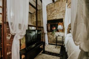um quarto com uma cama e uma televisão em Durmiendo como Reyes en la Rioja em Cihuri