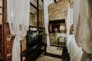 a bedroom with a bed and a television in it at Durmiendo como Reyes en la Rioja in Cihuri