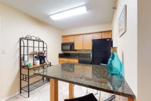 a kitchen with a table with a blue vase on it at Islander Condominiums I in Fort Walton Beach