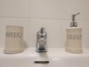 - un lavabo avec 2 bouteilles d'eau et un distributeur de savon dans l'établissement Ca l'Aloy, à Arfa