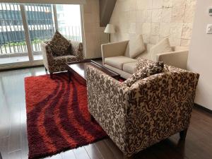 sala de estar con sofá y alfombra roja en St Isidro Suites Corporate Housing SPA & Wellness Center en Ciudad de México
