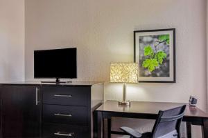a hotel room with a desk with a tv and a chair at La Quinta by Wyndham Miami Lakes in Miami Lakes