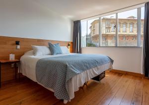 ein Schlafzimmer mit einem Bett und einem großen Fenster in der Unterkunft Fauna Hotel in Valparaíso