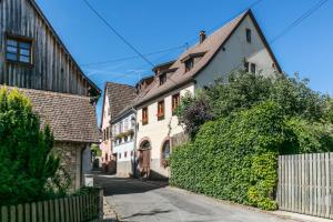 a street in a town with houses and a fence at Maison Gîte Au Tonnelier in Hunawihr