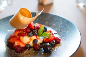 une assiette de fruits avec une cuillère à table au dessus dans l'établissement RELAIS DU TAURION, à Saint-Priest-Taurion