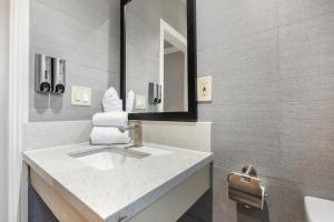 a bathroom with a sink and a mirror at Le Blanc Inn & Suites in El Monte +65 photos