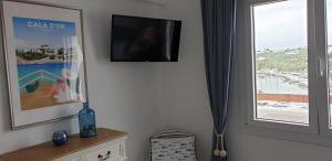 Telewizja i/lub zestaw kina domowego w obiekcie APARTMENT MARINA CALADOR HARBOURVIEW AIR CONDITION POOL GARDEN TERRASSE PORTO CARI spectacular location