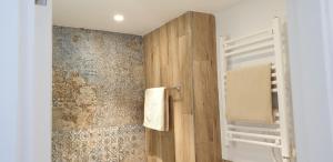 łazienka z prysznicem i drewnianą ścianą w obiekcie APARTMENT MARINA CALADOR HARBOURVIEW AIR CONDITION POOL GARDEN TERRASSE PORTO CARI spectacular location w mieście Cala d´Or