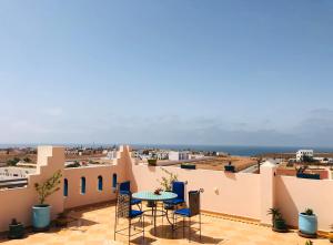 a patio with a table and chairs on a roof at Zakar Apartments in Mirleft