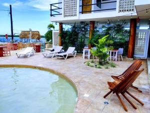 a patio with chairs and a swimming pool at Yuum Ha Boutique Hotel in Río Lagartos