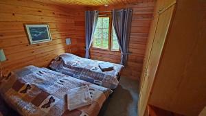 ein Schlafzimmer mit zwei Betten in einer Blockhütte in der Unterkunft Riekko Chalet in Rovaniemi