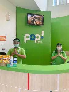 two people wearing gas masks standing at a counter at POP! Hotel Sangaji Yogyakarta in Yogyakarta