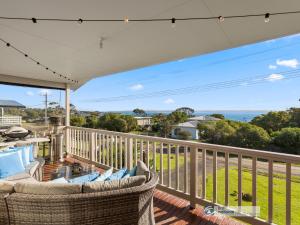 a porch with two wicker chairs and a balcony with a view at 13 Seacombe Grove in Ventnor
