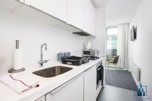 a kitchen with a sink, stove, and refrigerator at City View Apartments Rotunda in Birmingham