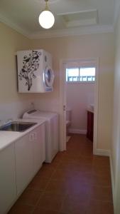 a white kitchen with a sink and a window at Cleggett Estate Holiday Cottage in Gisborne