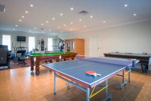 a room with a ping pong table and two pool tables at Cleggett Estate Holiday Cottage in Gisborne