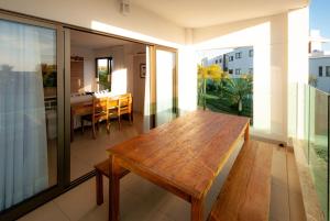 a room with a wooden table on a balcony at O Paraíso que você merece in Praia do Forte