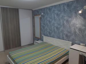 ein kleines Zimmer mit einem Bett und einem Spiegel in der Unterkunft Apartment near stadio Metalist Kharkiv in Kharkov