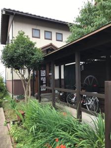 a house with a bike parked in front of it at ヨーコのお宿 わくわく in Toyama