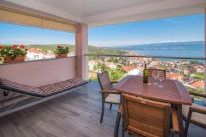 a balcony with a table and chairs and a view at Apartman Zoe Vrbnik in Vrbnik