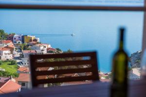 a bottle of wine sitting on a table with a view of the ocean at Apartman Zoe Vrbnik in Vrbnik