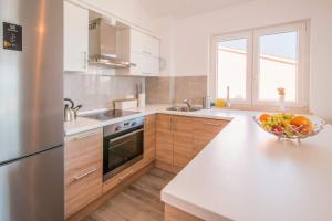a kitchen with a bowl of fruit on a counter at Apartman Zoe Vrbnik in Vrbnik