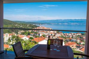 a table with a bottle of wine and two glasses at Apartman Zoe Vrbnik in Vrbnik