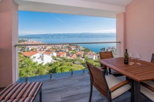 a balcony with a table and chairs and a view of the water at Apartman Zoe Vrbnik in Vrbnik