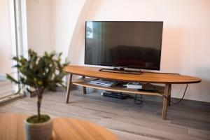 a flat screen tv sitting on top of a wooden table at Apartman Zoe Vrbnik in Vrbnik