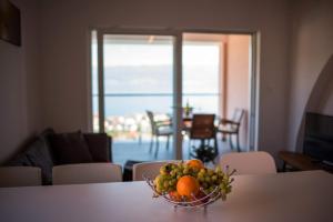 a bowl of fruit on a table in a living room at Apartman Zoe Vrbnik in Vrbnik