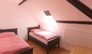 a attic room with two beds and a window at WÄLDER: Quartier Bierbronnen in Weilheim