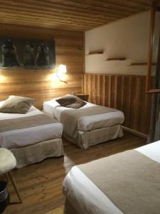 a hotel room with three beds in it at Alp'azur in L'Alpe-d'Huez