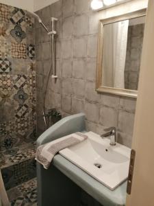 a bathroom with a white sink and a mirror at Aiolos Studios Κythnos in Kithnos +77 photos