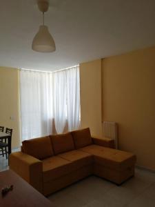 sala de estar con sofá marrón frente a una ventana en STANZA EUCALIPTO, en Caserta