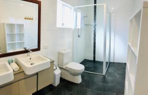 a bathroom with a toilet, sink, and shower at Riverview Tourist Park in Margaret River Town