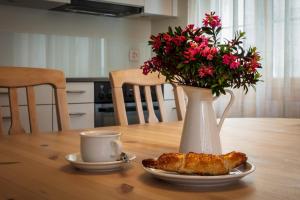 una mesa con un jarrón y un plato con un cruasán. en B&B Ursi en Andermatt