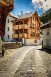 a large wooden building on a brick road at B&B Ursi in Andermatt