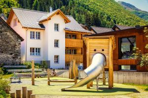 a playground with a slide in front of a house at B&B Ursi in Andermatt