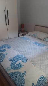 Una cama con una manta azul y blanca. en Apartman Dalmatino, en Sutivan
