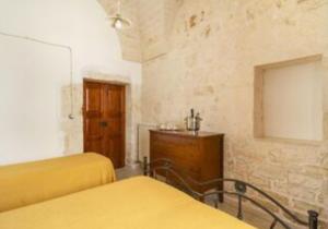 オストゥーニにあるAppartamento Il Barcoのベッドルーム1室(ベッド2台、木製ドレッサー付)