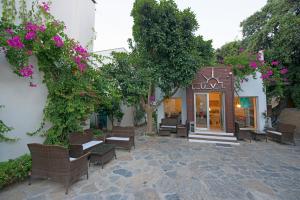 a patio with benches and flowers in front of a building at Costa Luvi Hotel Bodrum - All Inclusive in Gümbet