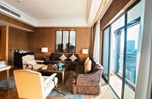 ein Wohnzimmer mit einem Sofa und Stühlen in der Unterkunft Gloria Resorts Jingdezhen Xishan Lake in Jingdezhen